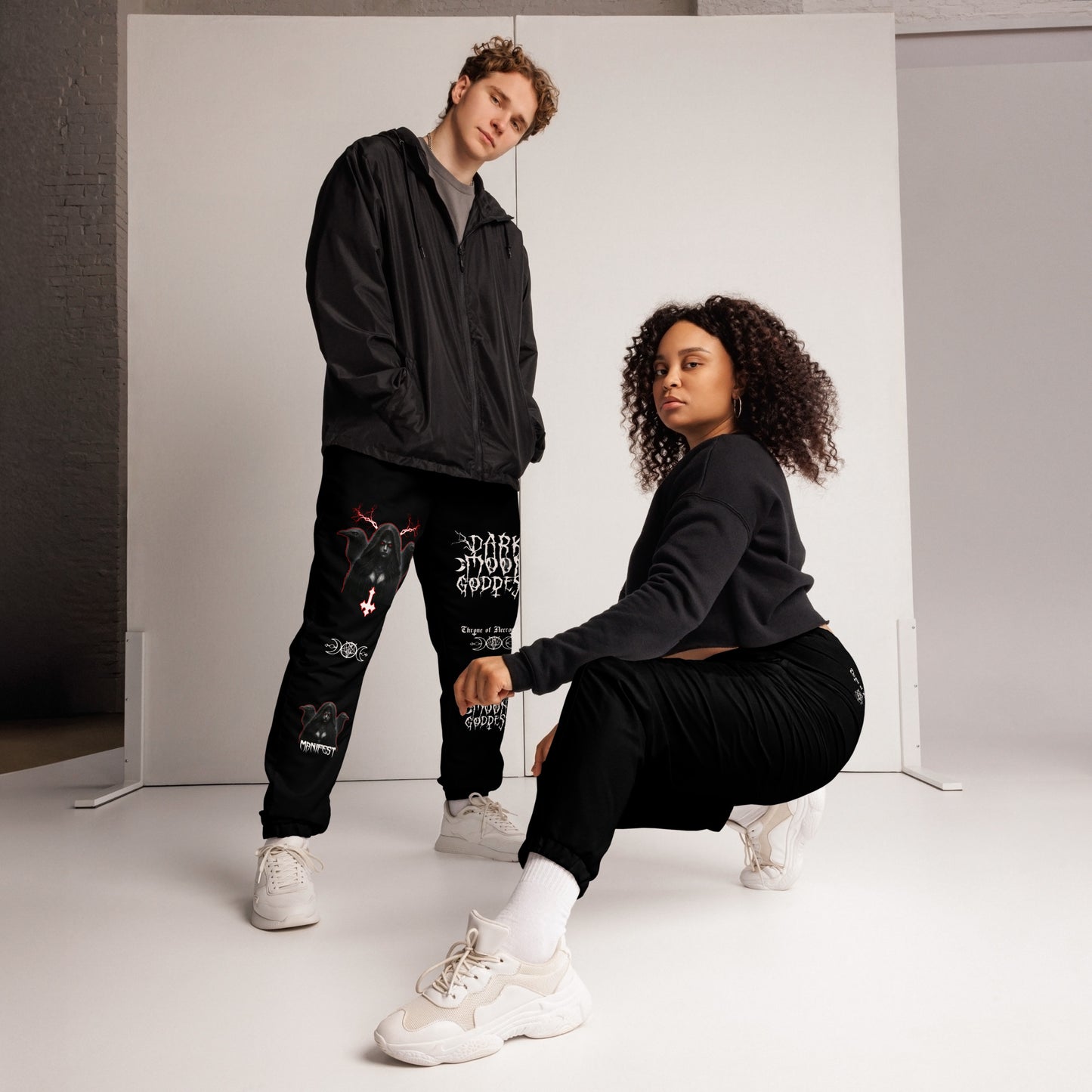 model wearing Black Joggers Pants Sweats Alternative Streetwear Lilith Ravens Inverted Cross Triple Moon Goddess Triple Moon Seal Sigil Throne of Necropolis Witch Occult Witchcraft Goetia side angle view