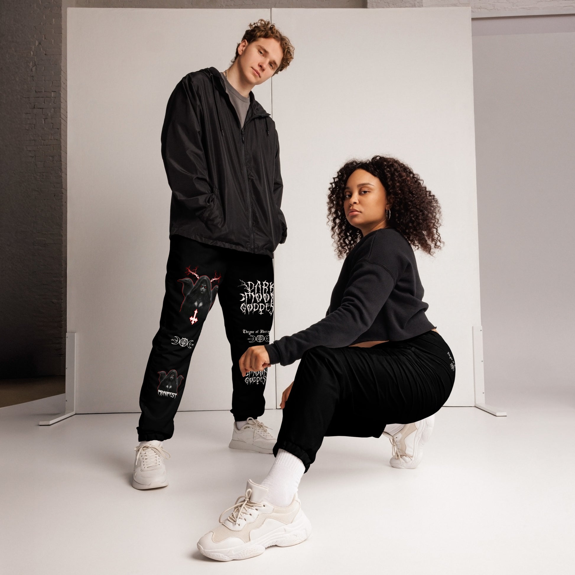 model wearing Black Joggers Pants Sweats Alternative Streetwear Lilith Ravens Inverted Cross Triple Moon Goddess Triple Moon Seal Sigil Throne of Necropolis Witch Occult Witchcraft Goetia side angle view